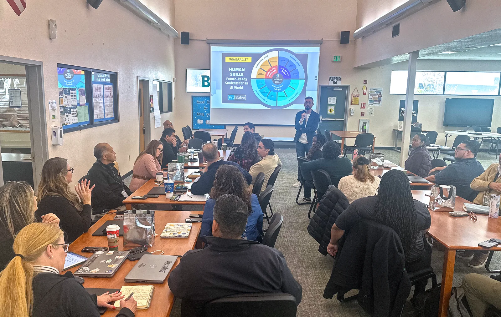 Presenter walks district staff through a Human Skills framework wheel on the screen behind him